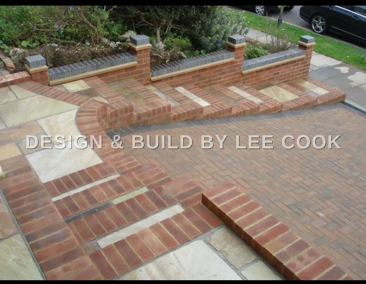 Red brick steps with sandstone treads beside a block-paved driveway